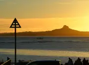 海洋博花火大会開始を待つ夕暮れ時、対岸の伊江島タッチューのシルエットがひときわ存在感を増す（本部町備瀬）
