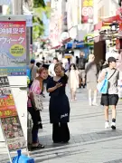 真夏の西日が照らす国際通り、日陰で笑顔の店員さん